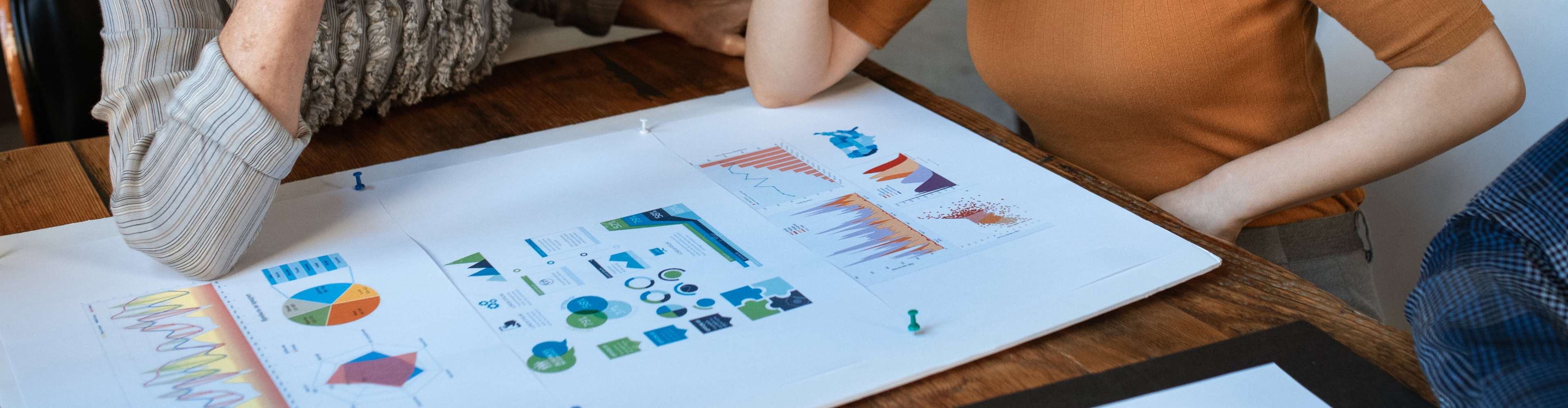 Two women looking at graphs on paper