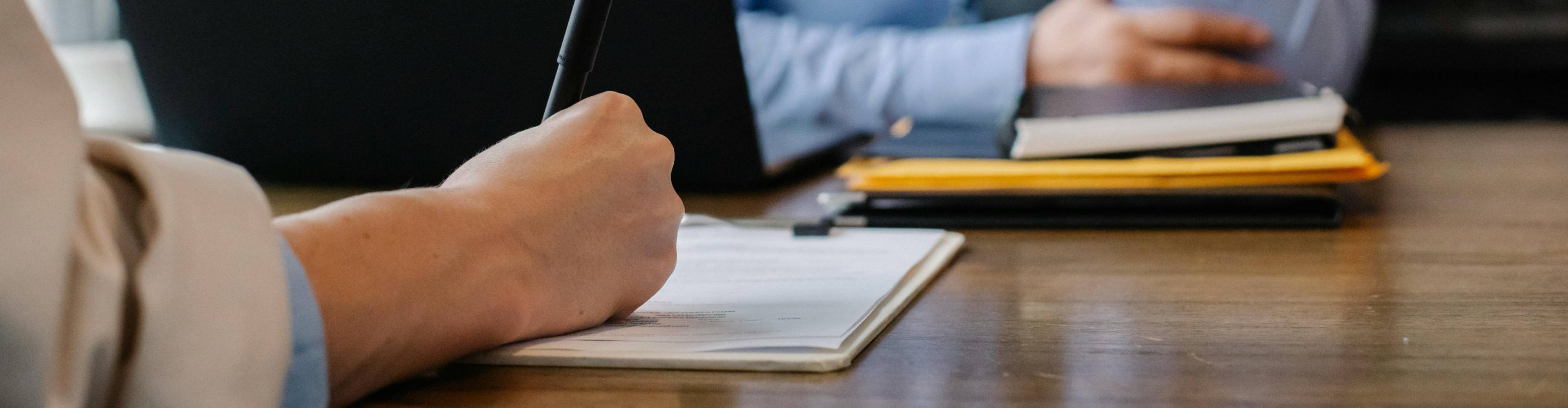 A person writing down on paper